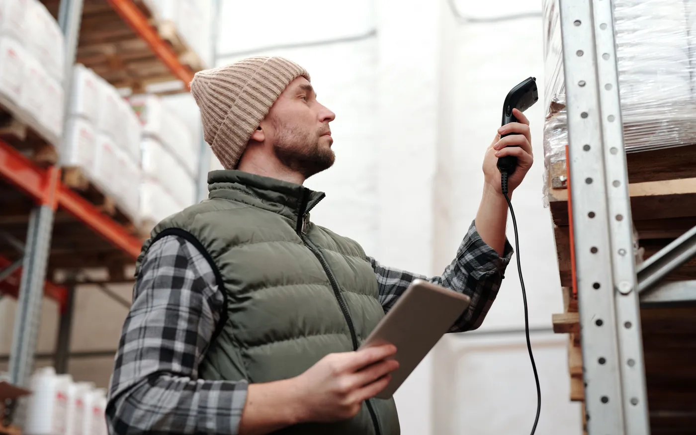 Lagermitarbeiter scannt mit Handscanner und Tablet die Ware im Regal
