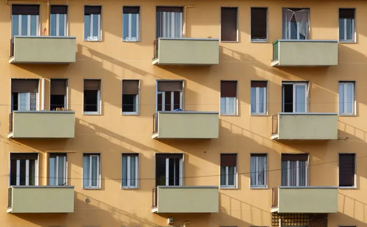 Fassade eines Mehrfamilienhauses mit Balkonen in warmem Licht